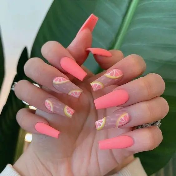 Matte neon pink nails paired with citrus slice designs create a refreshing and tangy look, embodying the zest of summer.