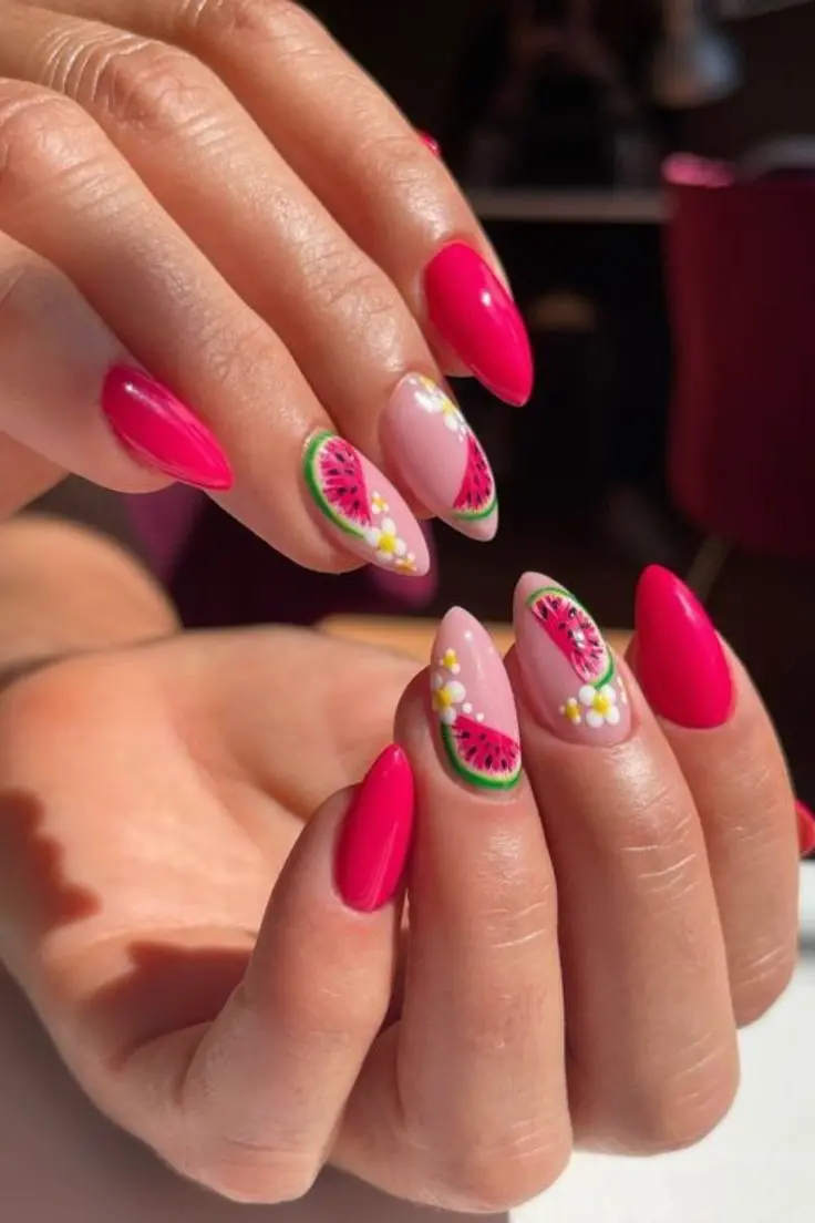 Vibrant summer nail design featuring glossy hot pink and soft nude tones, accented with playful watermelon slices and delicate floral motifs for a fun, seasonal look.