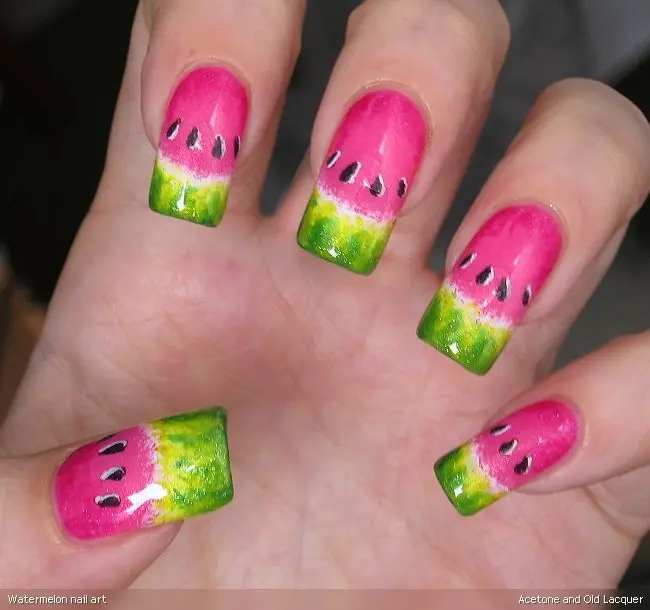 Vibrant pink nails with a glossy finish transition into a green gradient, detailed with black seeds to resemble a fresh watermelon, ideal for summer fun.