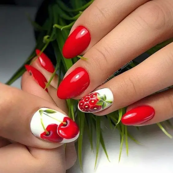 Glossy rounded-shaped nails in striking red with a single nail featuring a detailed strawberry design, exuding a fresh summer berry vibe.