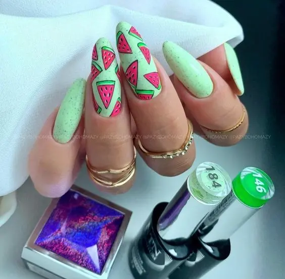 Minty green nails with vibrant watermelon slices offer a refreshing summer look, perfect for those who love a pop of color and fun on their fingertips.