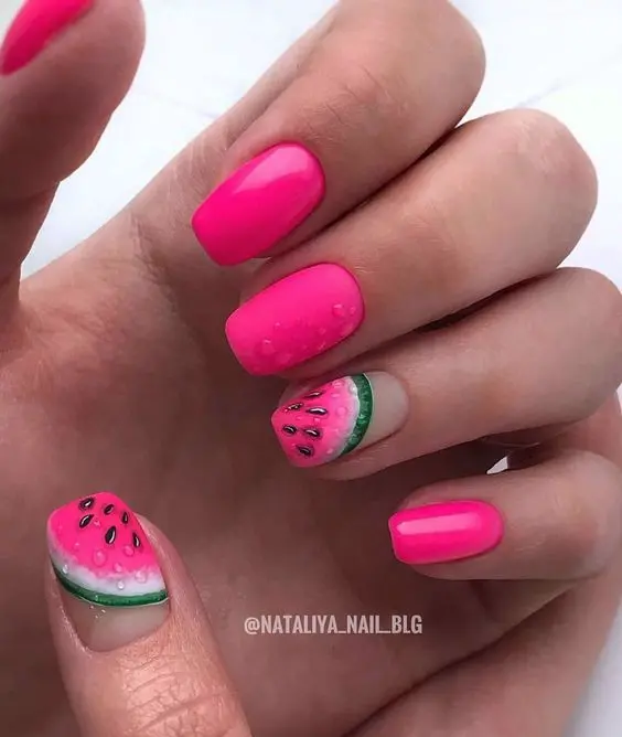 Chic, short nails in vibrant pink, with a watermelon pattern on one, making a fresh and trendy summer statement with a classic squoval shape.