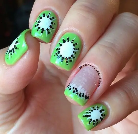 Short, square nails with a bright jelly green base, detailed with black kiwi seeds, create a refreshing look reminiscent of kiwi fruit slices, perfect for a fun summer style.