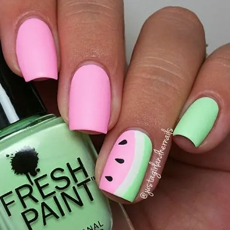 Matte pink and pastel green nails provide a soft backdrop for a playful watermelon slice design, creating a sweet summer treat for the eyes.