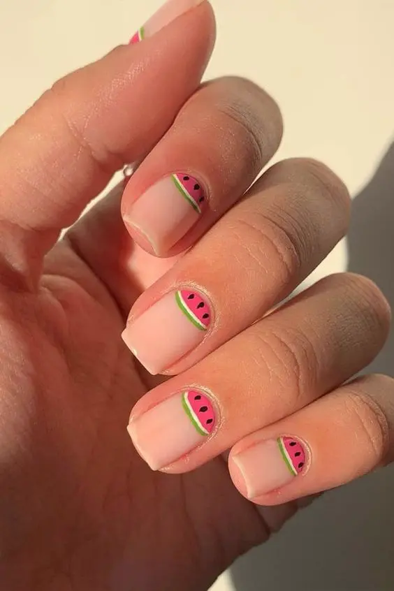 Square nails feature tiny watermelon slice accents, adding a subtle pop of summer to a clean and minimalist look.