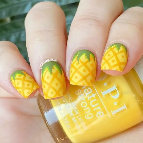 Short, square-shaped nails with a pineapple design against a sunny yellow base, a juicy addition to a summer-ready manicure.