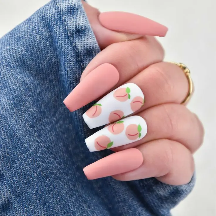 Long nails with a pastel peach base and white tips boast minimalist peach fruit designs, offering a subtle nod to the sweetness of summer.