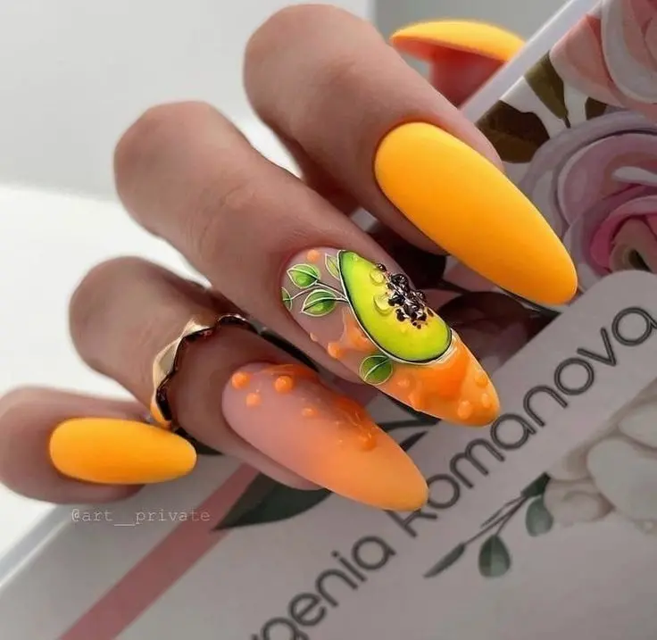 The matte yellow nails serve as a sunny canvas for a ripe avocado half, blending bold summer hues with a hint of tropical sophistication for an adventurous look.