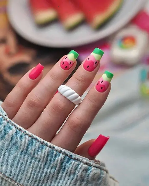 Rectangular nails with cute watermelon faces on a pink base exude a quirky summer fun, perfect for a playful seasonal look.