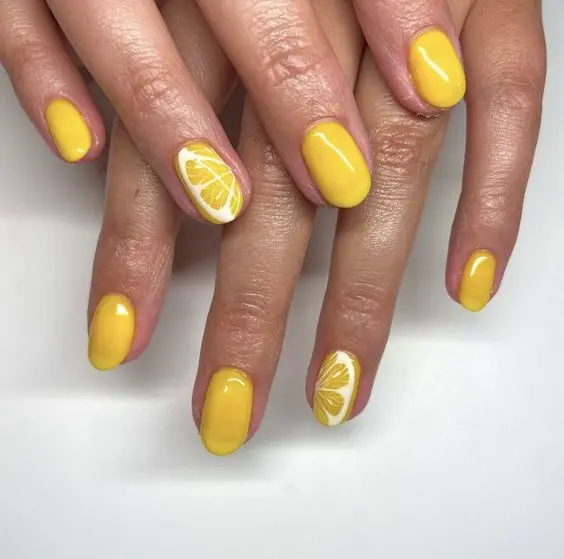 Oval nails with a bold yellow polish and detailed lemon slices create a lively and energetic look. This design is perfect for summer, symbolizing freshness and vitality, and adds a pop of color to any outfit.