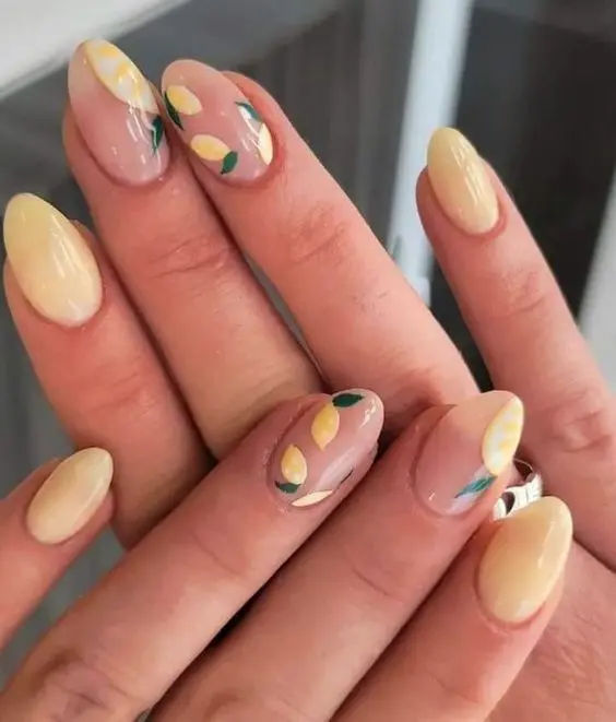 This almond-shaped yellow nail design features delicate leaf accents on a nude base, creating a fresh and nature-inspired look. Perfect for a vibrant summer style, the design symbolizes growth and renewal.