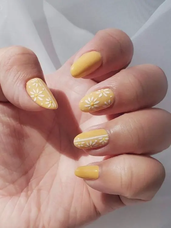 This set showcases rounded-shaped nails with a pastel yellow base and white daisy designs. The combination of simple, elegant florals and the soft yellow shade makes these nails perfect for a fresh and cheerful summer vibe.