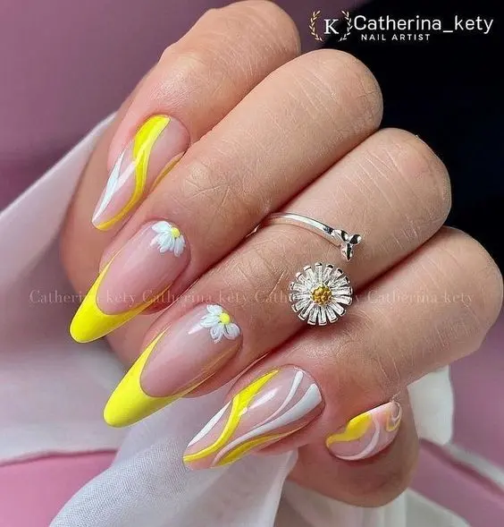 These nails boast a dynamic summer design with yellow and white swirls on long stiletto shapes. The accent nails feature daisy flowers, blending vibrant colors and floral patterns for a playful and stylish summer look.