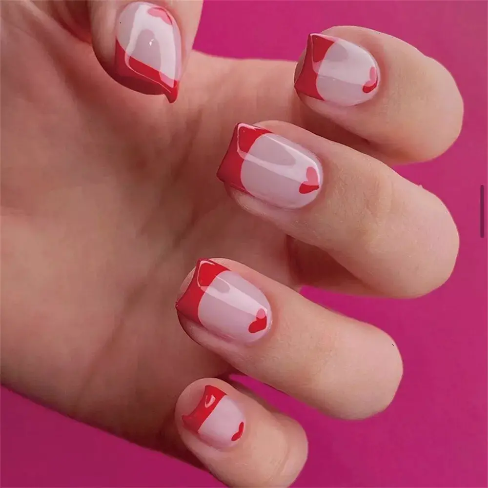 These nails feature a modern twist on the French manicure with a red heart accent on the tips. The light pink base contrasts beautifully with the vivid red tips and hearts, creating a playful yet sophisticated look, perfect for Valentine\'s Day or a romantic occasion.