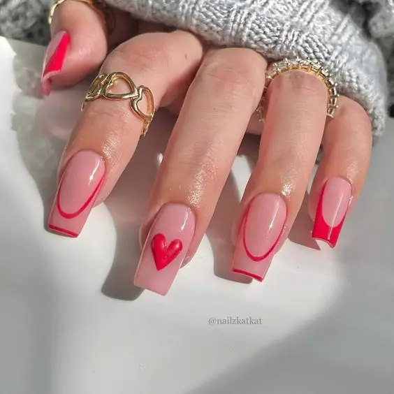 This design highlights a combination of glossy red nails and nude bases with delicate red heart patterns. The mix of short, square-shaped nails and intricate designs creates a playful yet elegant vibe, suitable for various occasions and styles.