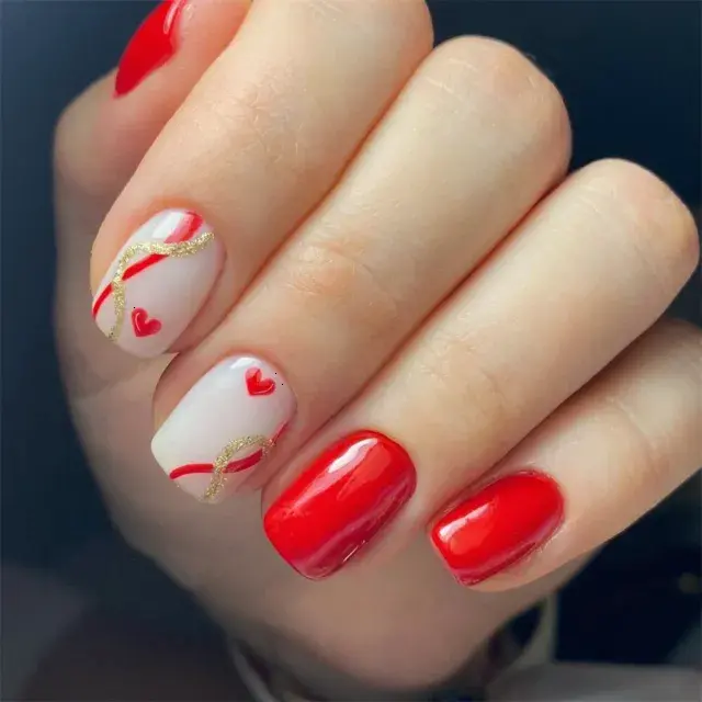 This nail art showcases a blend of solid red nails and nude nails with red heart designs. The matte finish and squoval shape create a sophisticated, modern look, ideal for expressing love and affection.