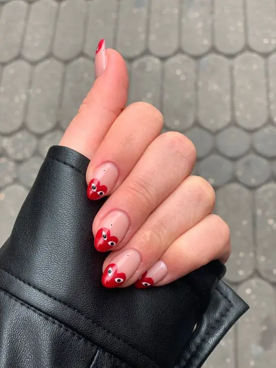 This set of red heart nails exudes a playful and whimsical vibe. The almond-shaped nails are decorated with red tips shaped like hearts, each with a pair of cute eyes, adding a fun and quirky touch to the design.