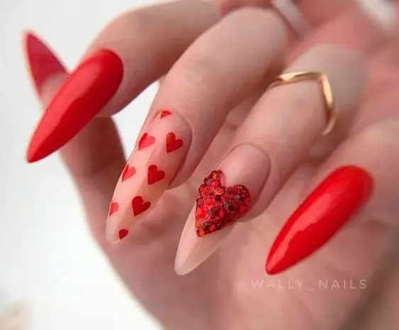 This red heart nail design features glittery red nails with red hearts. The stiletto shape and sparkling finish add a touch of glamour, making it perfect for romantic occasions.